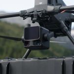Drohne mit montierter DJI Zenmuse L3 im Flug vor einem bewaldeten Hang.